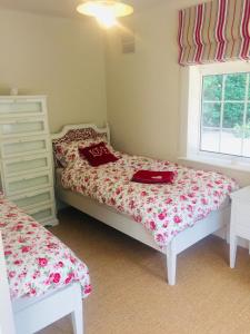 um quarto com 2 camas individuais e uma janela em Chadham Pines Cottage em Parkstone