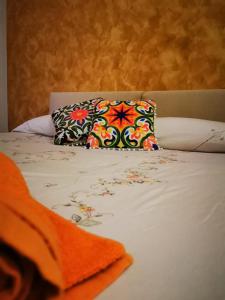 Azzurra’s House Pantelleria في بانتيليريا: سرير مع وسادة ملونة فوقه