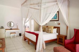 a bedroom with a bed with a canopy at Batonka Guest Lodge in Victoria Falls