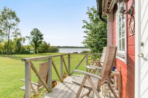 a porch with two chairs and a view of the water at Cottage with own jetty in Ljungbyhed in Ljungbyhed