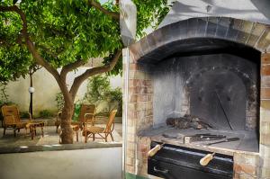 an outdoor oven with a tree and a patio at N’zina’s home in Custonaci