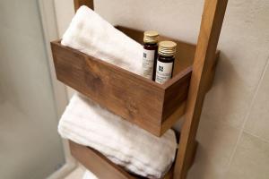 a wooden shelf with towels in a bathroom at Residenza SubitoSanto - Appartamento 5A "Obizzi" in Padova +9 photos