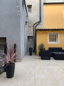 a courtyard with chairs and potted plants on a building at Residenza SubitoSanto - Appartamento 5A "Obizzi" in Padova