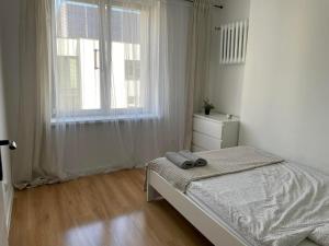 biała sypialnia z łóżkiem i oknem w obiekcie 3K Ochotnicza 9 w mieście Lublin