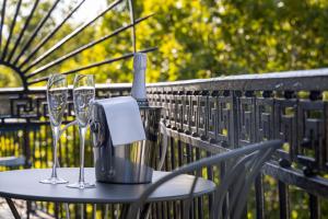 a table with glasses and a bottle of wine on it at Hotel Abbatial Saint Germain in Paris