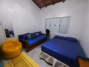 a bedroom with two beds and a couch and a mirror at A VER O MAR FLATS in Caraguatatuba