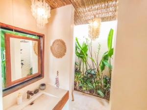 baño con lavabo, espejo y plantas en The River Hideaway en General Luna