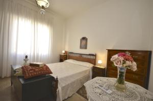 a bedroom with a bed and a vase of flowers on a table at N’zina’s home in Custonaci