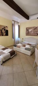 a bedroom with two beds and a table and chairs at DIMORA AL SARACENO in Ferrara