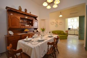 a dining room with a table and a green couch at N’zina’s home in Custonaci