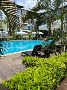 un resort con piscina e palme di Accra Pearl in City a Accra
