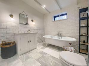 a bathroom with a tub and a sink and a toilet at Little Owl A beautiful bolt-hole for couples in Aldeburgh