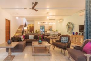 a living room with a couch and a table at StayVista at Villa Arcadia with Alfresco Dining in Candolim