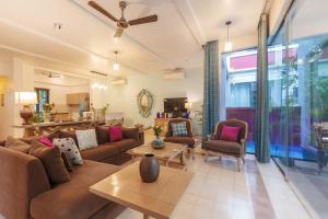 a living room with a couch and a table at StayVista at Villa Arcadia with Alfresco Dining in Candolim