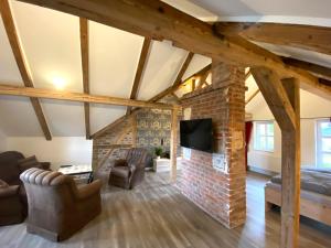 a living room with a brick fireplace and a tv at Ferienwohnungen zur alten PuppenFabrik in Sonneberg