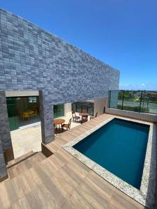uma casa com uma piscina e um pátio em Apartamento c/ piscina , Praia do Francês. em Marechal Deodoro