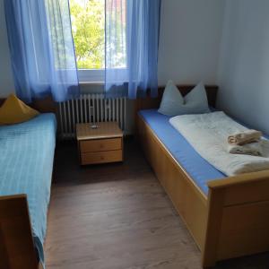 Habitación pequeña con 2 camas y ventana en Haus Christine, en Halblech