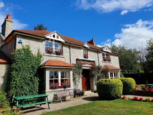 a building with a green bench in front of it at The Redgarth in Oldmeldrum