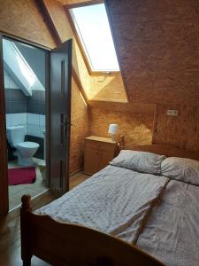 a bedroom with a bed and a bathroom with a window at Siedlisko na Zaciszu pokoje z aneksem in Kąty Rybackie