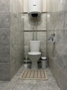 a bathroom with a toilet with a light on the wall at Милая и уютная однокомнатная квартира в г.Тараз in Taraz