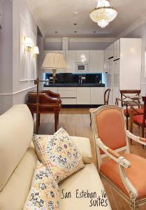 a living room with a couch and chairs and a kitchen at SUITES SAN ESTEBAN 16 Real in Seville