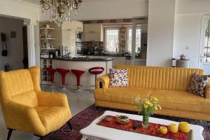 a living room with two couches and a kitchen at Gemütliche Villa mit Pool, extravagant, luxuriös in Ula