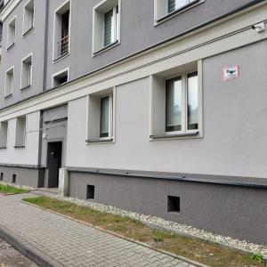 un edificio gris con ventanas laterales en Apartament Tuwima, en Zabrze
