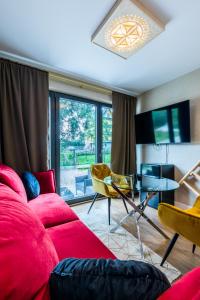 - un salon avec un canapé rouge et une table dans l'établissement Aparthome Tatra, à Biały Dunajec