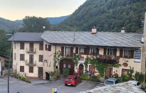 a large building with a red car parked in front of it at Bed & Breakfast Barba Bertu in Frassino