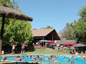 un groupe de personnes dans une piscine dans l'établissement Camping La Fundicion, à Cazalla de la Sierra