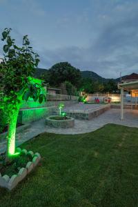 a park with a green tree in the grass at Bungalow Episkopiko in Ioannina