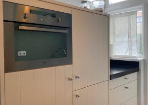 a kitchen with a stove and a microwave at Next To Sea in Vlissingen +8 photos