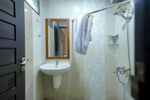 a bathroom with a sink and a mirror at RedDoorz @ Avros Guest House Medan in Medan
