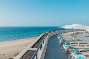 uma fila de cadeiras e guarda-sóis numa praia em Iberostar Playa Gaviotas All Inclusive em Morro del Jable