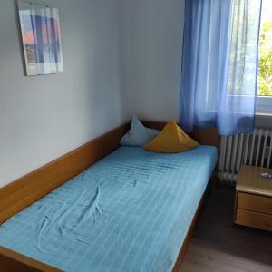 a bed in a room with a blue mattress and a window at Haus Christine in Halblech