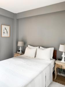 1 dormitorio con 1 cama blanca grande y 2 lámparas en Stylish Lakeside Apartment 1 hour from Madrid Pantano de San Juan, en San Martín de Valdeiglesias