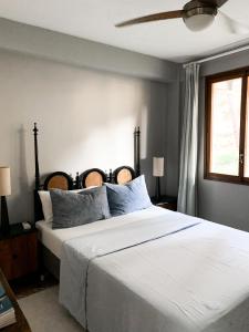 1 dormitorio con 1 cama grande con sábanas blancas y ventana en Stylish Lakeside Apartment 1 hour from Madrid Pantano de San Juan, en San Martín de Valdeiglesias