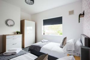 Tempat tidur dalam kamar di Spacious 3 bedroom Penarth home, garden & parking
