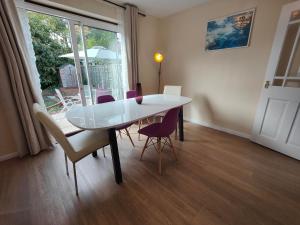 uma sala de jantar com uma mesa branca e cadeiras em Piping House 4bedroom em Otterbourne
