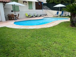 Villa Paradiso, logement avec piscine, Nice Nord في نيس: مسبح في ساحة فيها كراسي وطاولة