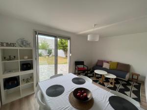 uma sala de estar com uma mesa e um sofá em La Palmerais Dinard - 5 min de la plage em Dinard