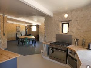 een keuken met een fornuis en een eetkamer bij L'auguste maison d'hôtes in Valensole