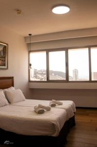 a bedroom with a large bed with two towels on it at Haifa Peak in Haifa