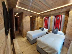 2 łóżka w pokoju z drewnianymi ścianami w obiekcie Quartz-Montblanc w Chamonix-Mont-Blanc