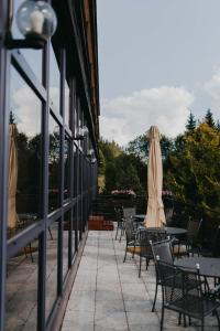 a row of tables and chairs with umbrellas on a patio at OREA Hotel Špičák Šumava in Železná Ruda