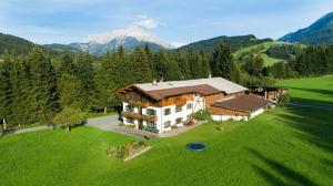 an aerial view of a house in a green field at Bauernhof Niederfilzboden in Fieberbrunn +28 photos