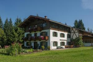 a large white house with a balcony at Bauernhof Niederfilzboden in Fieberbrunn