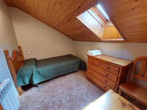 a small bedroom with a bed and a wooden ceiling at Casa Moreno in Hospital