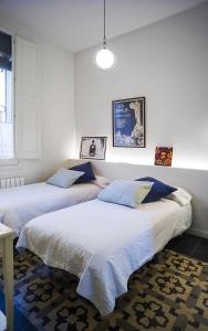 two beds in a room with white walls at Cal Peó ByBCardedeu in Cardedeu