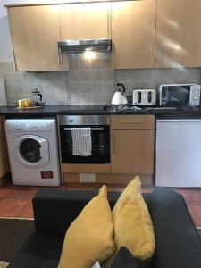 a living room with a couch and a kitchen at 1Bed Golfhill Cottage in Dunblane